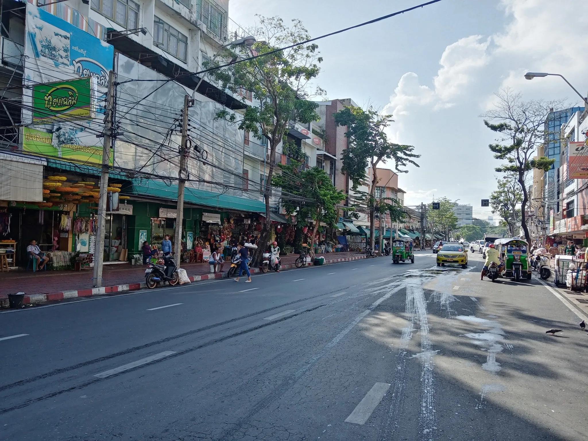 Chakphet Road through Pak Khlong Talat, with shopfronts and hanging garlands