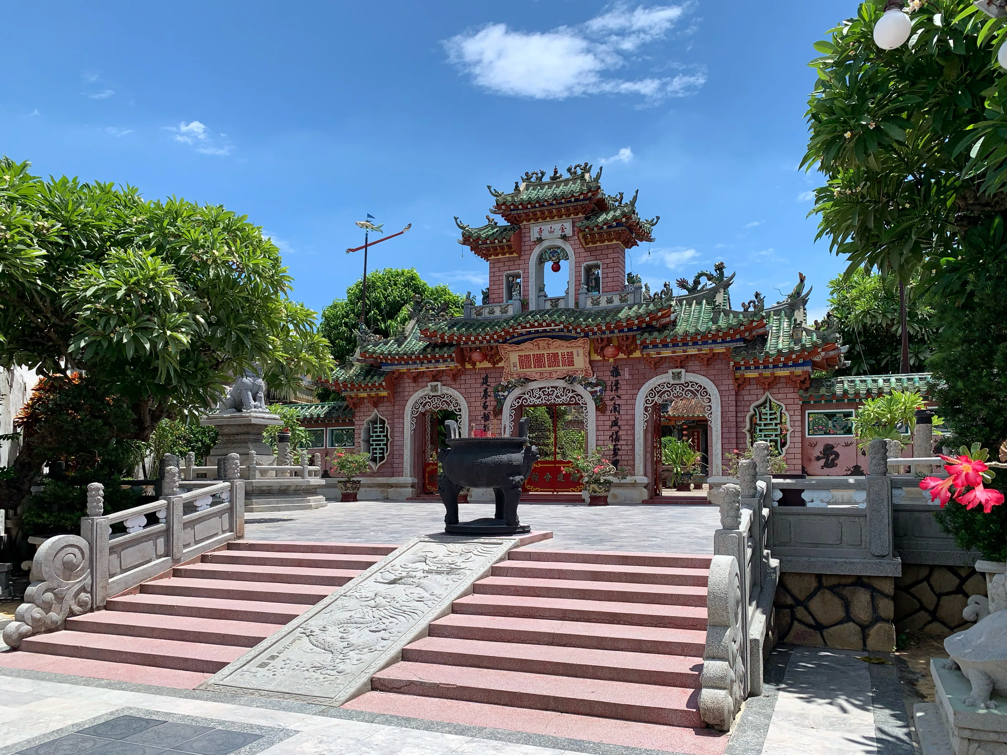 The courtyard and ornate hall of the Fujian Assembly Hall in Hoi An, seen from inside the gate