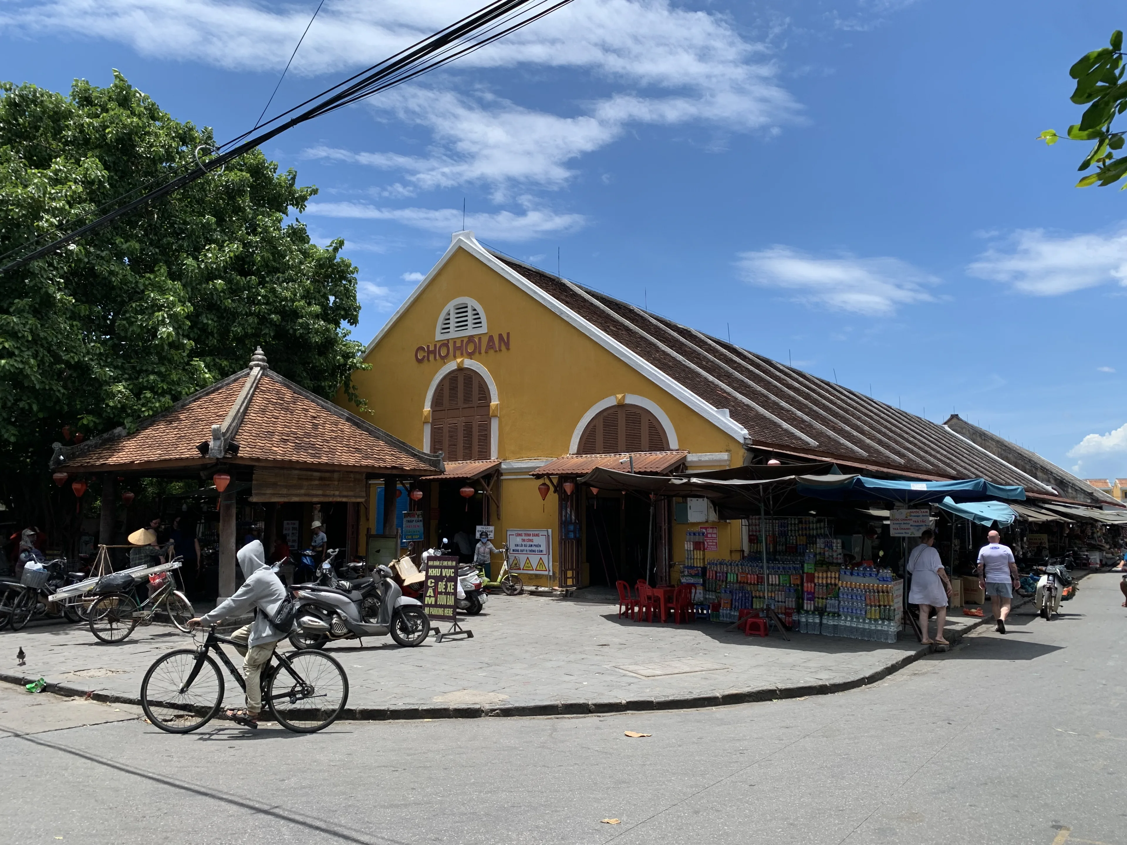 The yellow gable of Hoi An Market on Trần Phú, lettered CHỢ HỘI AN, with stalls along the street
