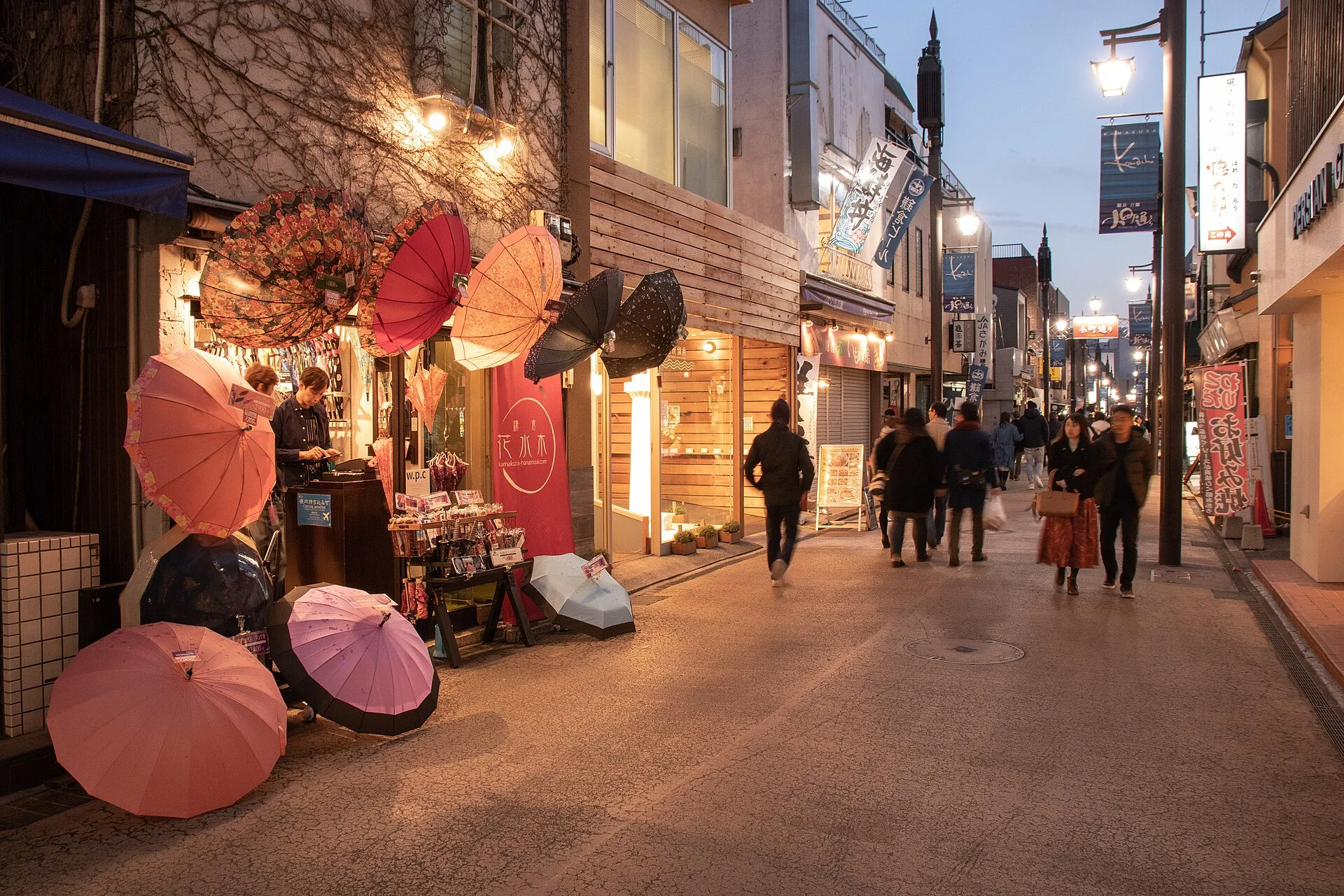 People and illuminated shops on Komachi-dori at dusk