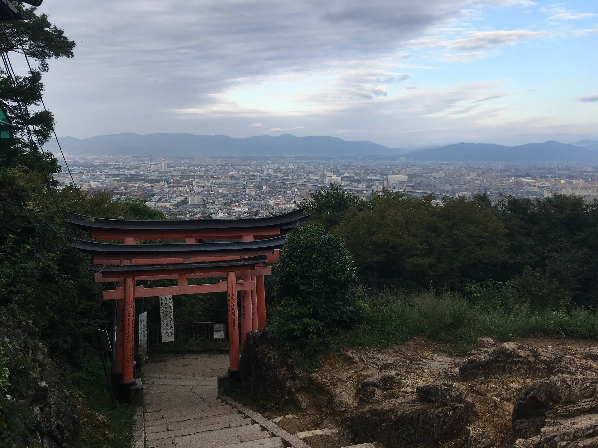 四辻附近可见京都市景,前景有鸟居和山路台阶