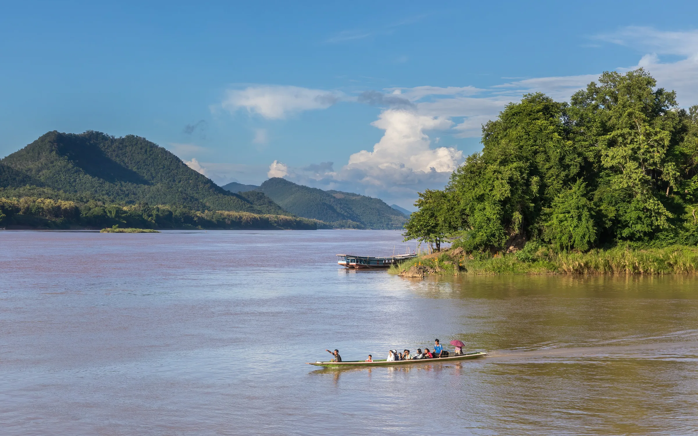 A pirogue crossing from the Nam Khan toward the Mekong at Luang Prabang
