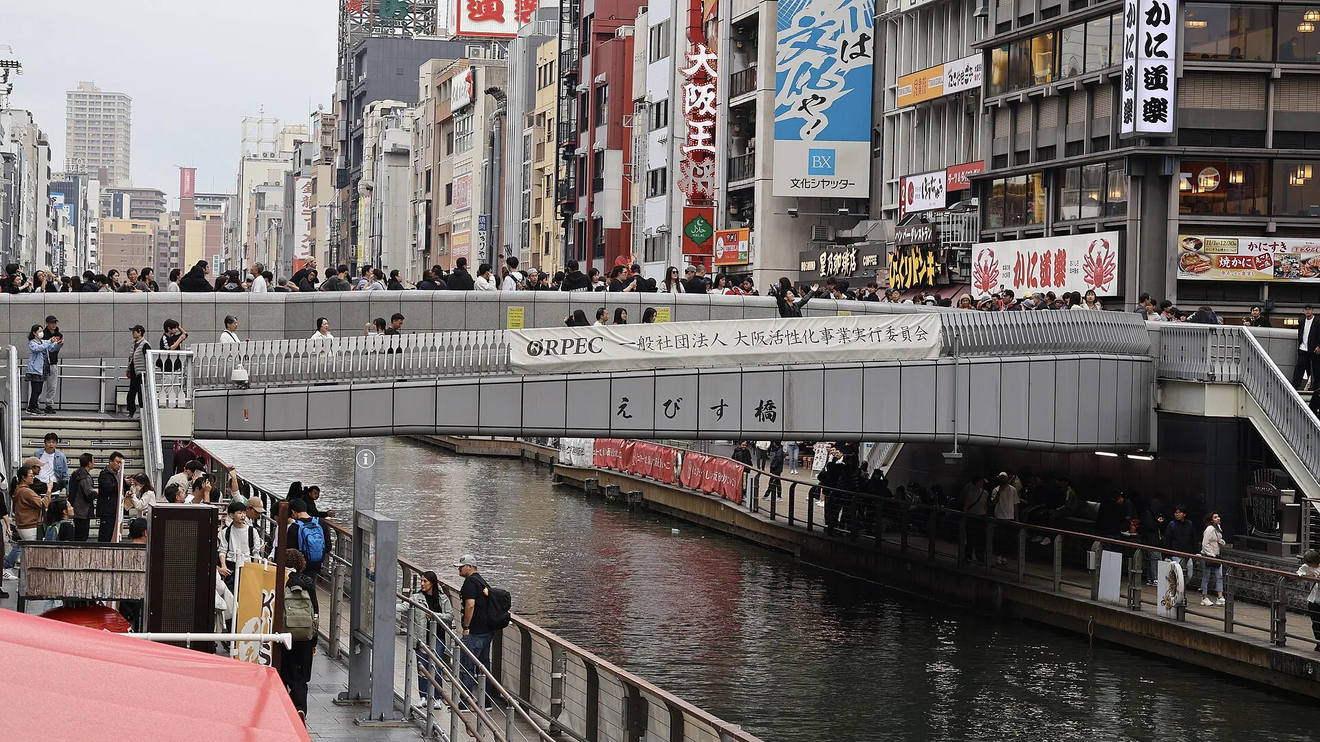People crossing Ebisu Bridge over the Dotonbori Canal