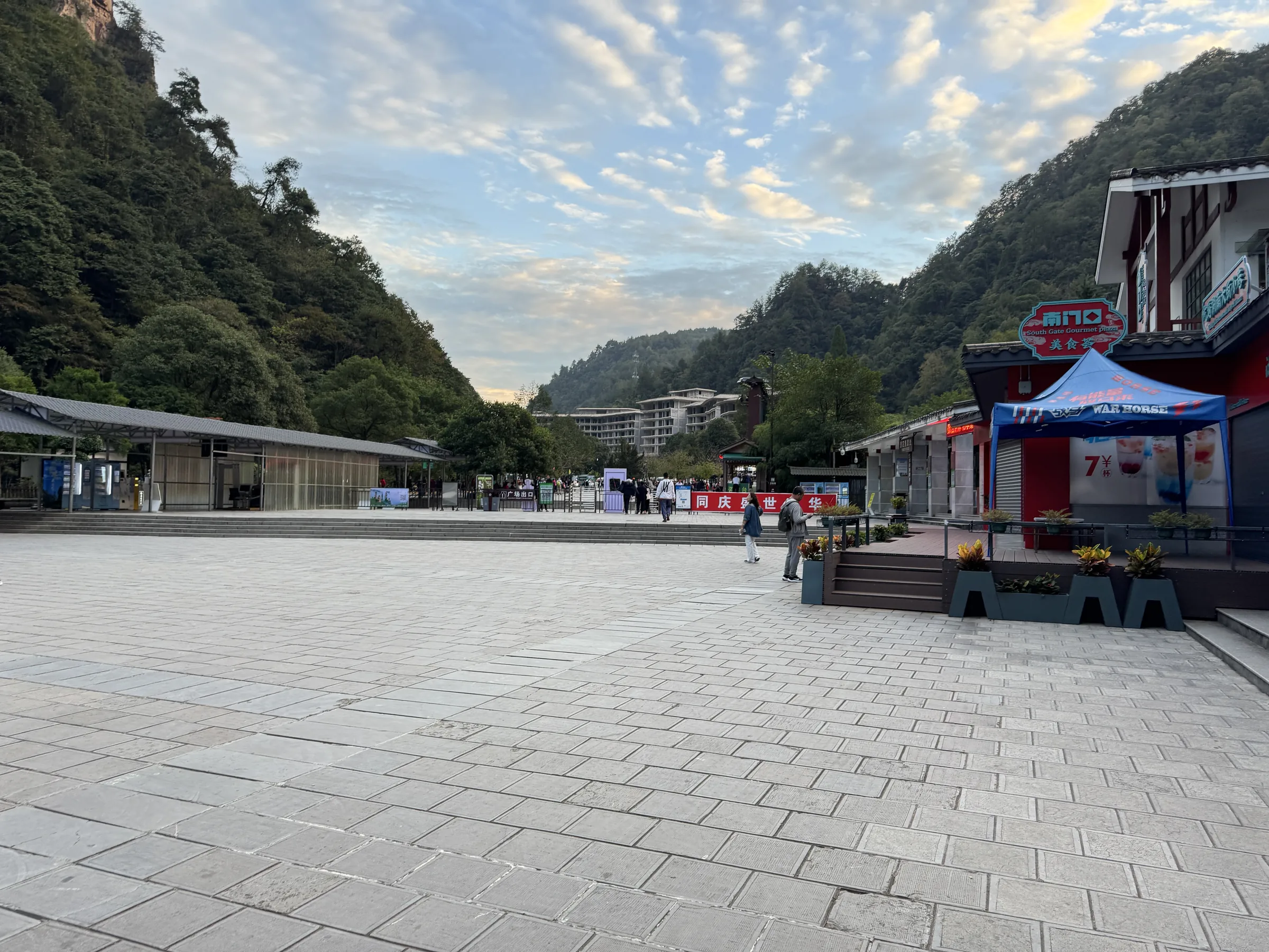 The south gate of Zhangjiajie National Forest Park with sandstone cliffs rising behind the entrance plaza